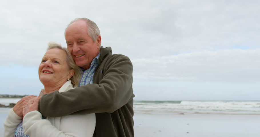 Front view of old Caucasian couple embracing each other at beach. Old Caucasian couple interacting with each other.
