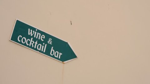 Rovinj, Croatia - 11 27 2018: Green sign pointing in direction where is coctail and wine bar.