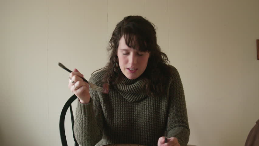 POV shot: Young pretty woman finishes a meal at home and puts down utensils