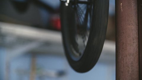 An old mountain bike's front tire spins freely while hanging in blue garage