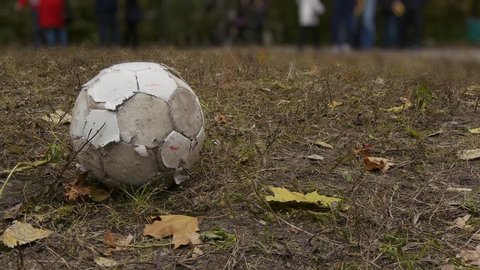 old shabby soccer ball lies on the ground, childhood, footballer from the slums