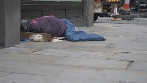 A homeless man sleeping on the street.