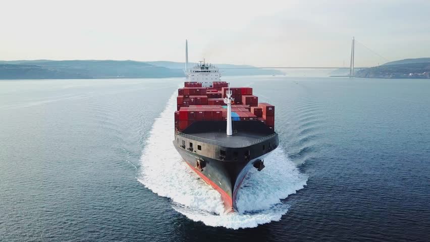 ISTANBUL - FEB 3, 2019: Bow and front deck of container ship on ride. Aerial frontal view as cargo ship ploughs through waters at sea. Half loaded vessel moves at calm water of Bosphorus shipway. Clos