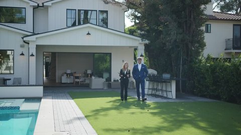 Realtor woman showing a new home to a wealthy client at open house 