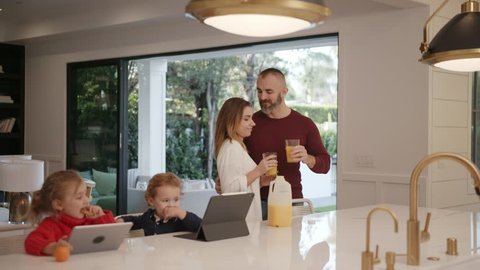 Young happy family having breakfast in modern kitchen 