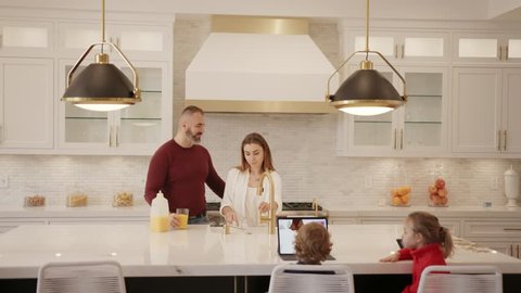 Young happy family having breakfast in modern kitchen 