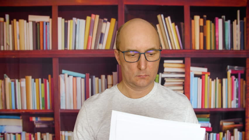 Adult white man read paper documents conract and swaying head sissagree with text finance close up portrait male face in glasses. Locked shot Royalty-Free Stock Footage #1024003328
