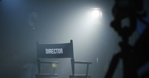 Medium shot of a director sitting in his chair on a film set