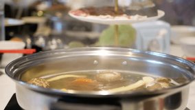 Cooking hotpot (Shabu-shabu) with a bunch of vegetables and meat in the pot - famous get-together meal in Thailand, among the locals, for a group of people or family 