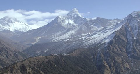 Mount Everest and Himalaya Mountains helicopter wide shot POV AERIAL view of snowcapped rocky mountains with village in Nepal Tibet China