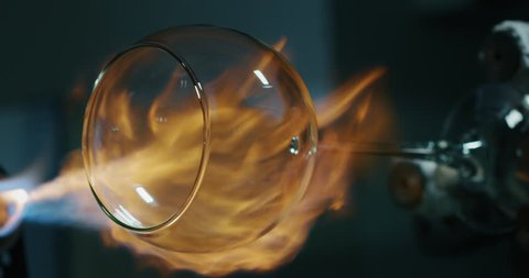 Slow motion macro of experienced glass blower working with flame on a handmade wine glass from crystal in a workshop. Shot in 8K. Concept of handmade, high quality, artisan, made in Italy,glass blower