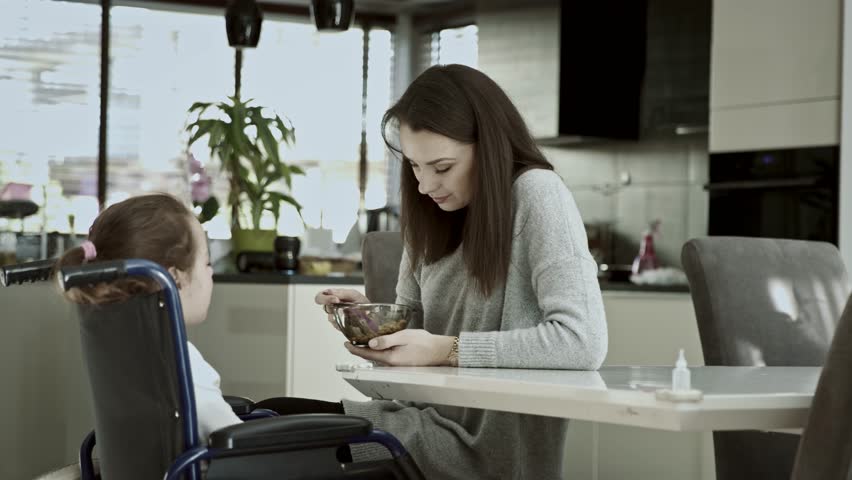 Young mother taking care of her disabled child | Shutterstock HD Video #1024022651