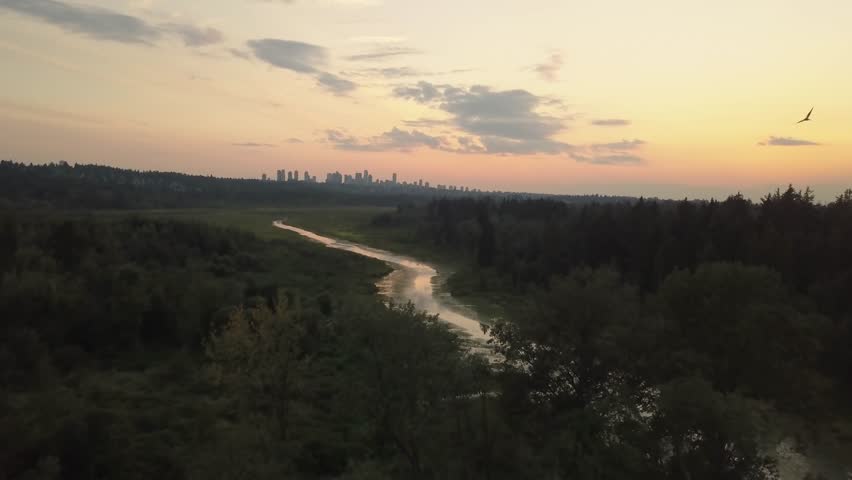 Aerial view of Burnaby Lake in the city during a vibrant sunset. Taken in Greater Vancouver, British Columbia, Canada.