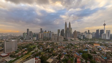 Beautiful and Dramatic Kuala Lumpur city skyline overlooking an expressway with busy light trails from night to day at dawn. Kuala Lumpur, Malaysia. Pan up motion timelapse.