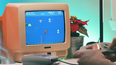 MONTREAL, CANADA - February 2019 : Vintage Mario Bros video game being played on TV 80's 90's style. Retro looking desk and setup with old television CRT monitor.