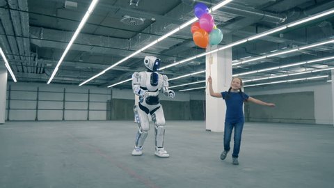 Teenage girl is dancing with balloons and walking with a human-like droid