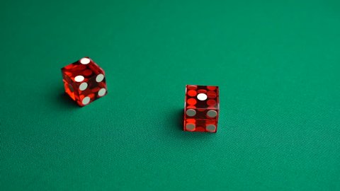 The shooter rolls twelve on dice. Slow motion two red dice, craps, thrown on green tomentum background at casino, Ace deuce. Gambling game with random result for adults.