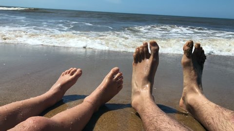 Legs POV at the beach, children feeling water. Point of view