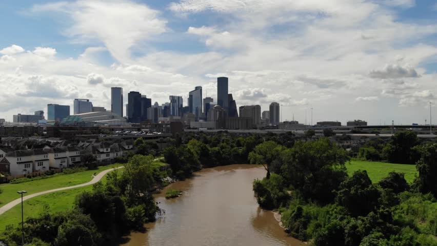 Descending Drone Footage to the Water Level of Buffalo Bayou with the City of Houston Skyline in the Background