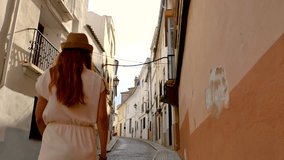 The narrow streets of the touristic town of Oliva, in the community of Valencia, in Spain, Europe. The video features the traditional architecture, narrow streets, and white or lighted colored facades