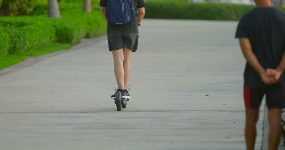 Riding an electric scooter on a sidewalk