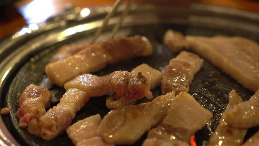 Korean food - close up of sliced grilled pork barbecue style cooking on stove