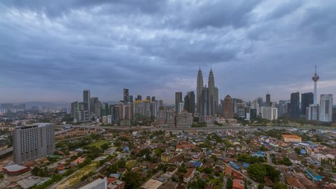 Beautiful and Dramatic Kuala lumpur city skyline overlooking an expressway with busy light trails from night to day at dawn. Kuala Lumpur, Malaysia.