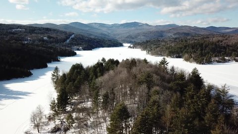 Flight over little river state park. Snow covered river, bare forest, river splits, drone shot rising up and moving forwards over trees. 