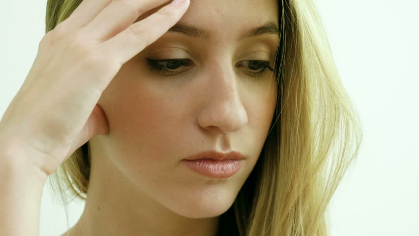Close-up shot of attractive unhappy young blonde woman with sad look. 4K