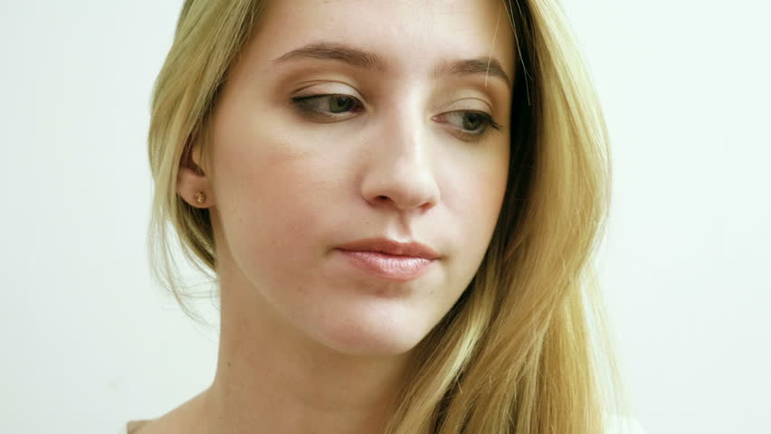 Portrait of beautiful young blonde woman with a sad look and natural makeup. 4K