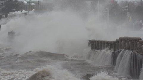 Massive wild waves hit seawall at city shoreline in wind snow and ice storm
