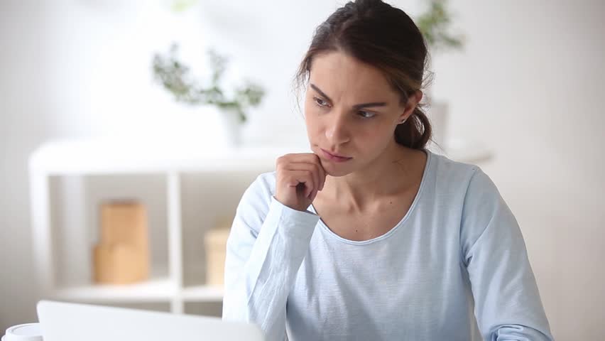 Thoughtful doubtful hesitant young woman with unsure face thinking of problem solution, uncertain female student making difficult decision lost in thought having writers block searching for new ideas Royalty-Free Stock Footage #1024093454