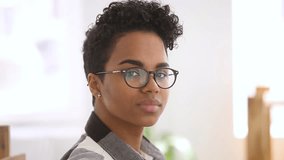 Happy confident african american girl student with stylish haircut wearing optical glasses looking at camera, smiling millennial black mixed race woman professional posing alone for video portrait