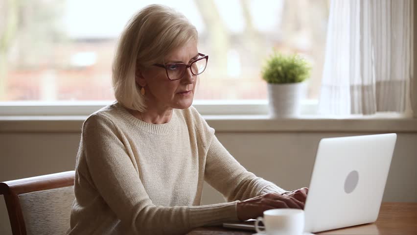 Senior woman using laptop feeling discomfort from dry irritated fatigued eyes taking off glasses, older mature businesswoman tired of computer worker suffering from blurry vision eyestrain problem | Shutterstock HD Video #1024093982