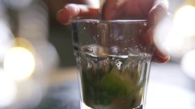 Close up of hand stirring mojito cocktail