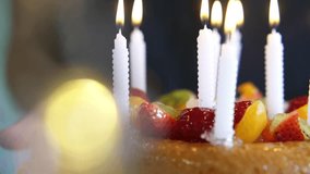 Delicious fruit birthday cake with lit candles