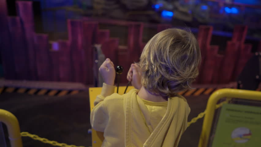 Slowmotion shot of a little boy visiting a science museum for children. Boy plays with a model of an excavator. Children trying different professions concept