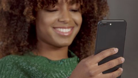 closeup of mixed race black woman with movil phone. focus on her hand with phone