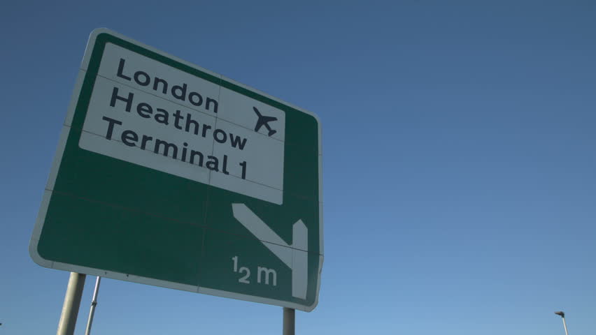 Heathrow Airport Sign with aircraft Flyover: Road sign for london heathrow airport with jet airliner flying overhead Royalty-Free Stock Footage #1024107236