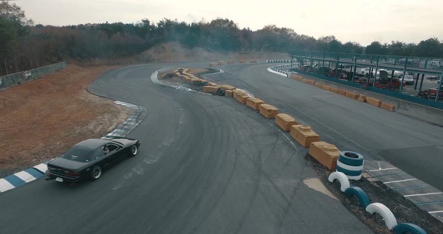 Close Up Aerial Drone Tracking Shot Following an Import Race Car as it Goes Around the Track.