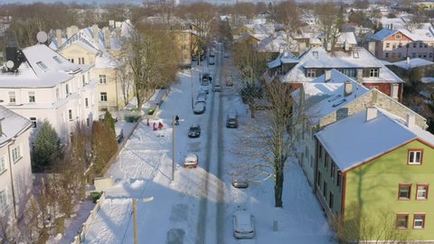 Aerial over a suburb street covered in thick snow and car tracks. Shot in Kalamaja / Põhja-Tallinn district