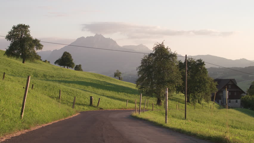 Paved road leading to the farmhouse amid the splendour of the Alps, Switzerland.
