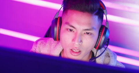 close up of Young Asian Handsome Pro Gamer having live stream and playing in Online Video Game