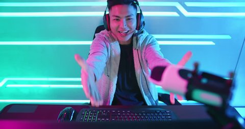 Young Asian Handsome vlogger having live stream and playing in Online Video Game