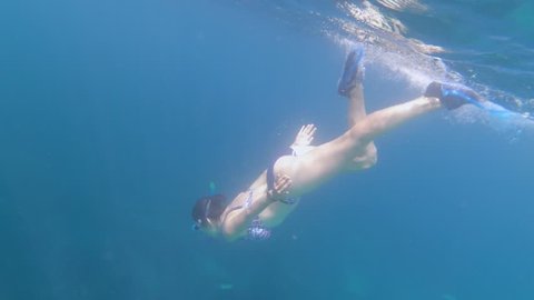  Underwater view of sexy girl in bikini snorkeling in tropical sea water