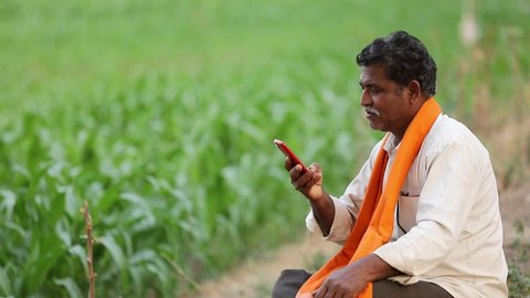 Indian farmer using mobile phone at field