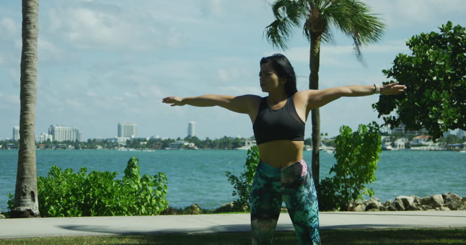 YOUNG FIT GIRL WORKING OUT IN FRONT OF THE OCEAN