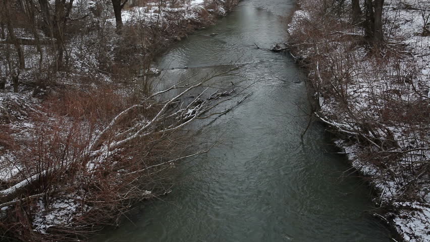 Video of the river, shot in winter, along fallen trees. View from the bridge.
