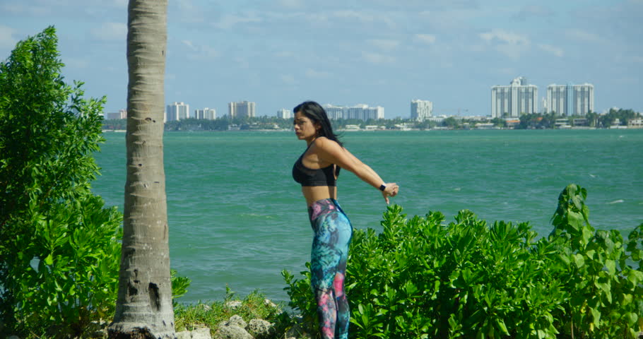 YOUNG FIT GIRL WORKING OUT IN FRONT OF THE OCEAN