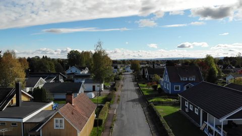 Detached houses in smaller city in Sweden. With colorful and typical Swedish and European style. The black and neutral road leading the view forward.